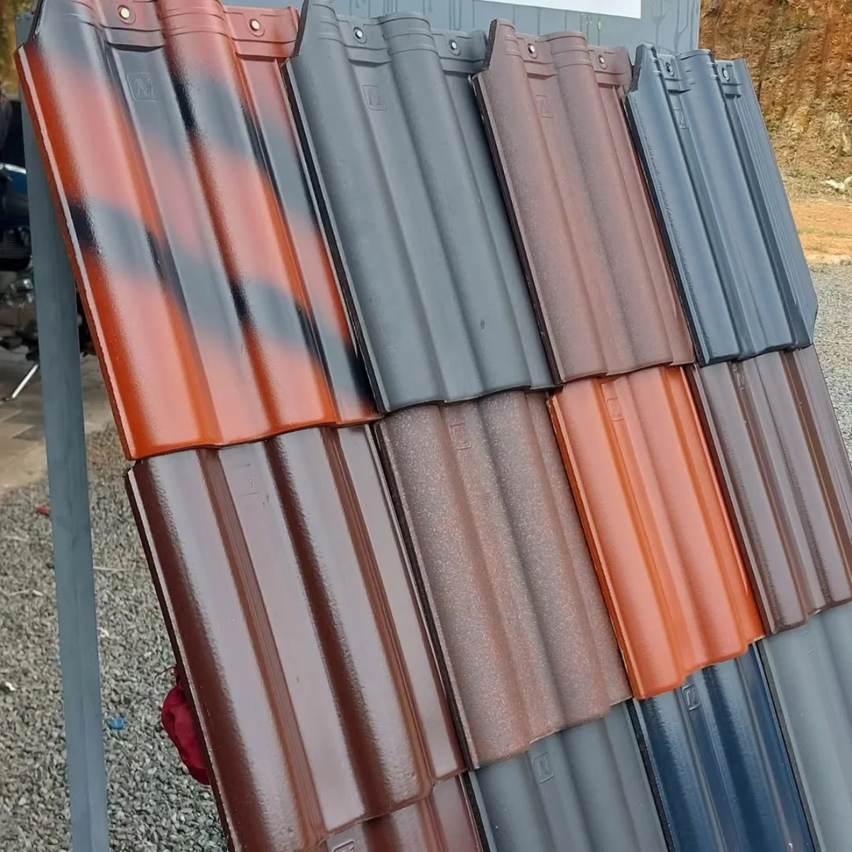 Rak display yang menampilkan contoh genteng keramik mengkilap dalam berbagai pilihan warna dan gradasi