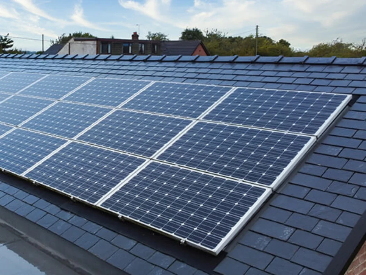 Instalasi panel surya berwarna biru kehitaman yang terpasang rapi di atas atap genteng rumah