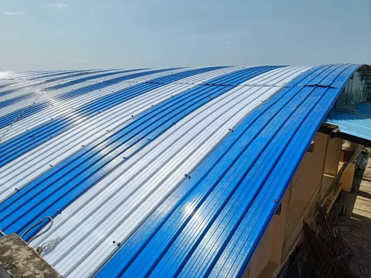 Hamparan luas atap PVC bergelombang dengan kombinasi garis warna biru dan putih di bawah sinar matahari