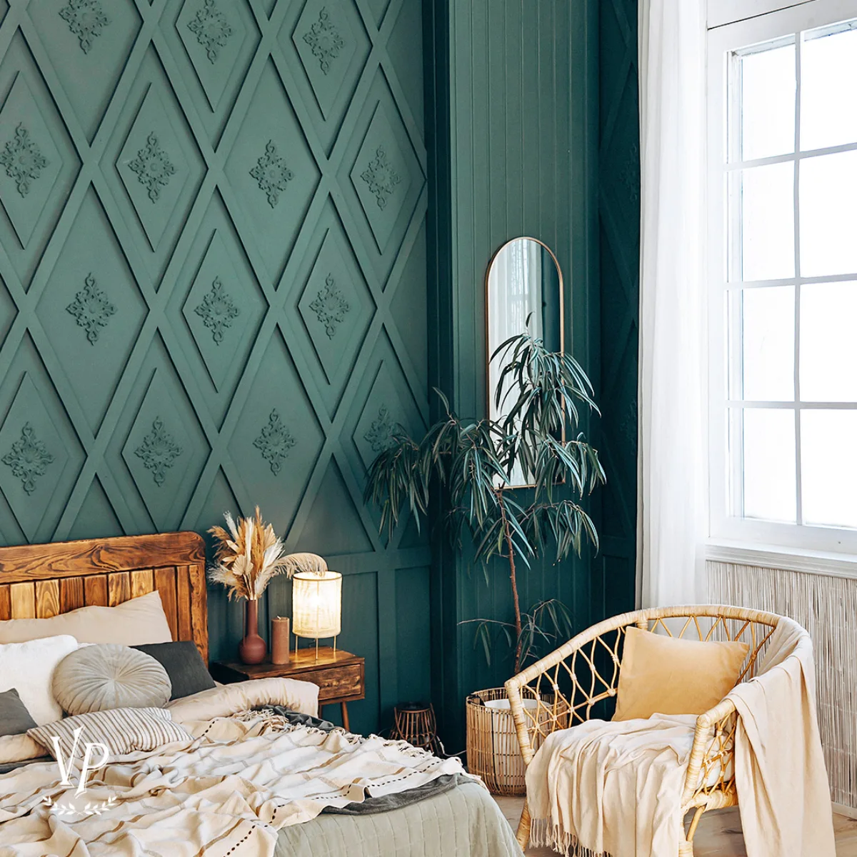 Kamar tidur dengan dinding bertekstur geometris hijau tua, tempat tidur kayu dengan bantal-bantal dan selimut, meja samping tempat tidur kayu dengan lampu menyala dan dekorasi kering, kursi anyaman rotan dengan bantal kuning, dan tanaman hijau besar di dekat jendela besar dengan gorden putih.