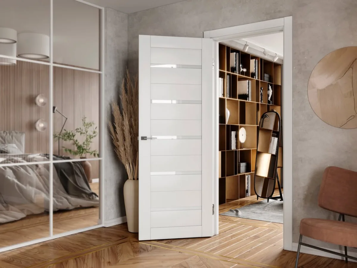 Pintu kamar satu daun minimalis elegan dari kayu berwarna putih dengan desain garis horizontal, menyatu dengan interior modern bernuansa hangat.