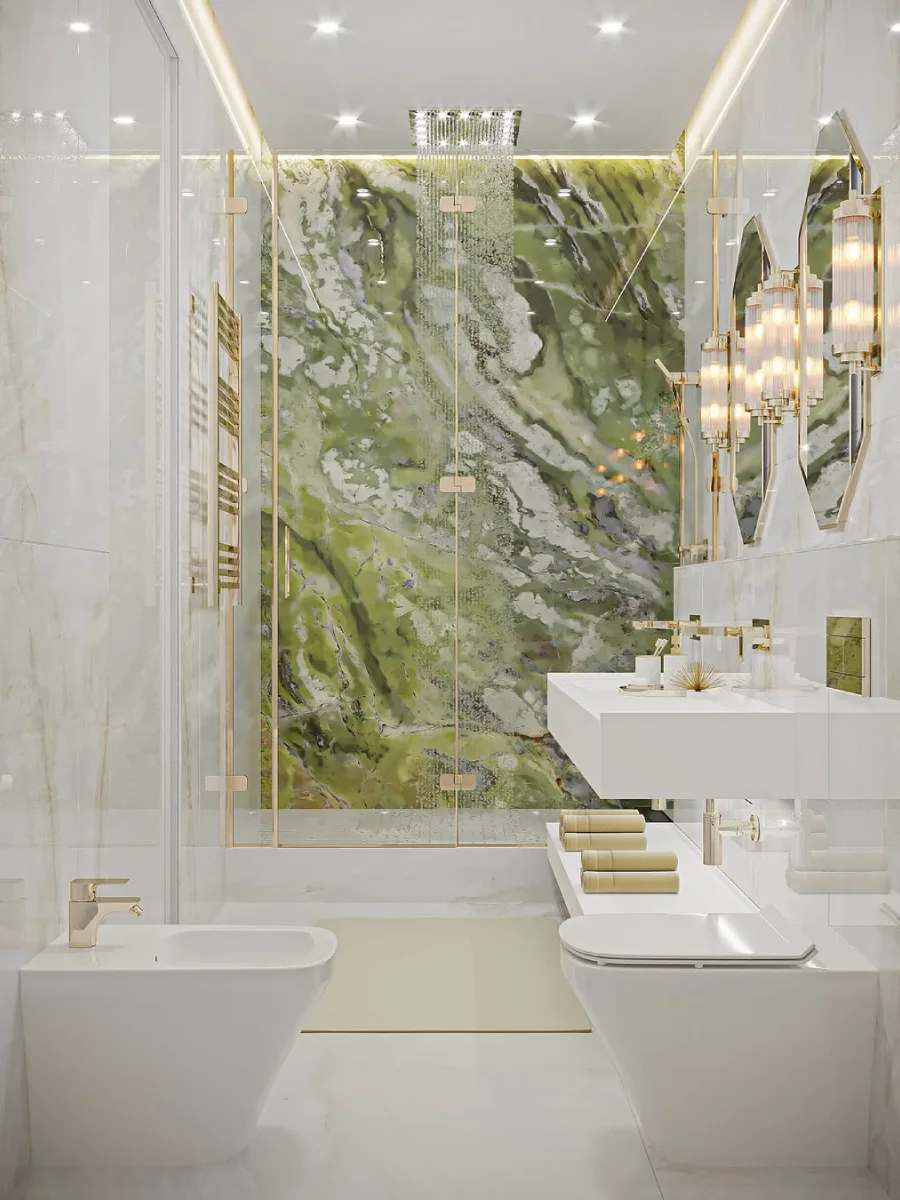 Kamar mandi elegan dengan dinding shower marmer hijau, perlengkapan mandi bernuansa emas, dan meja wastafel putih melayang