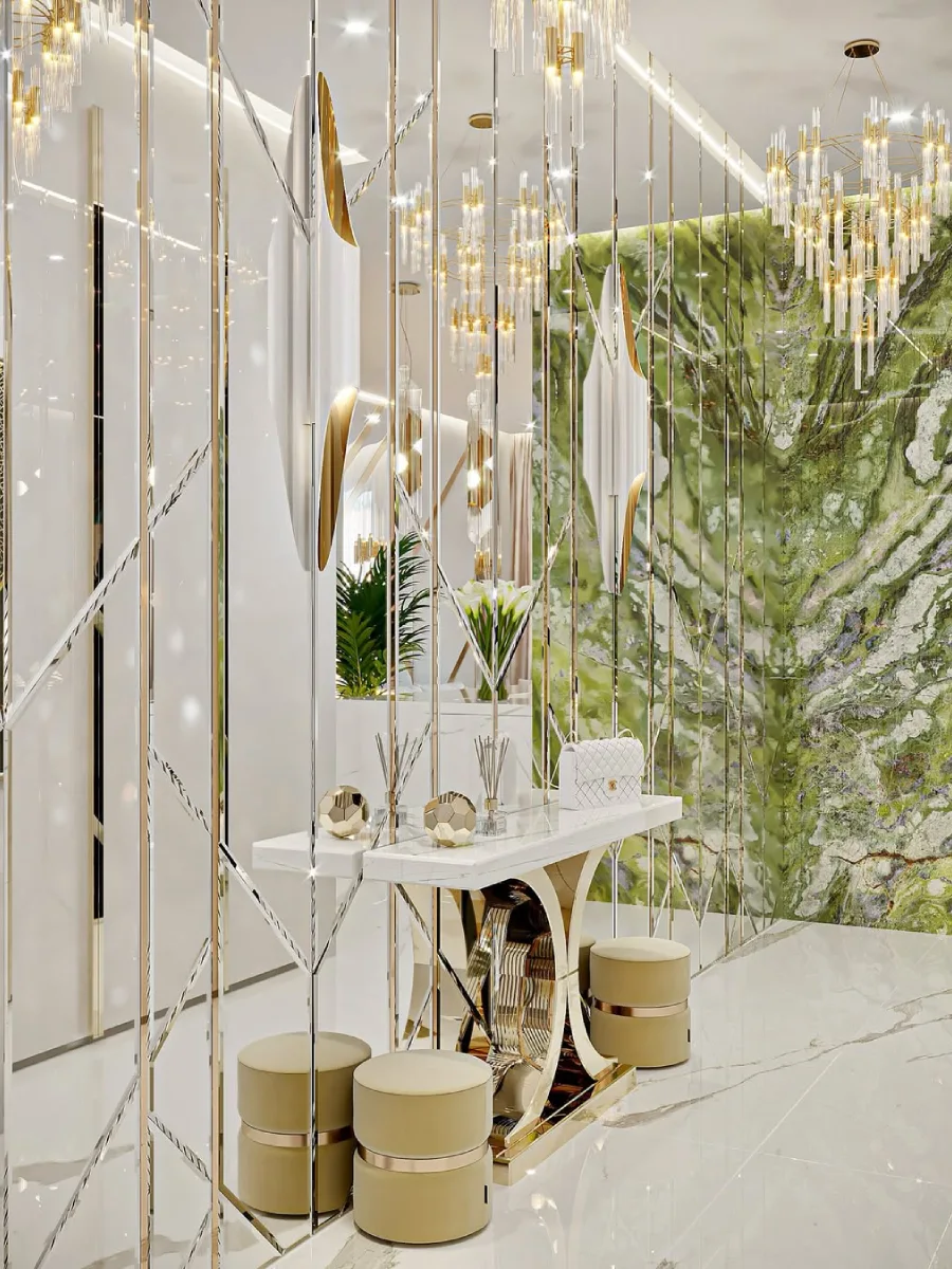Detail meja konsol putih beraksen emas di lorong dengan dinding cermin bergaris geometris yang memantulkan ruangan marmer hijau