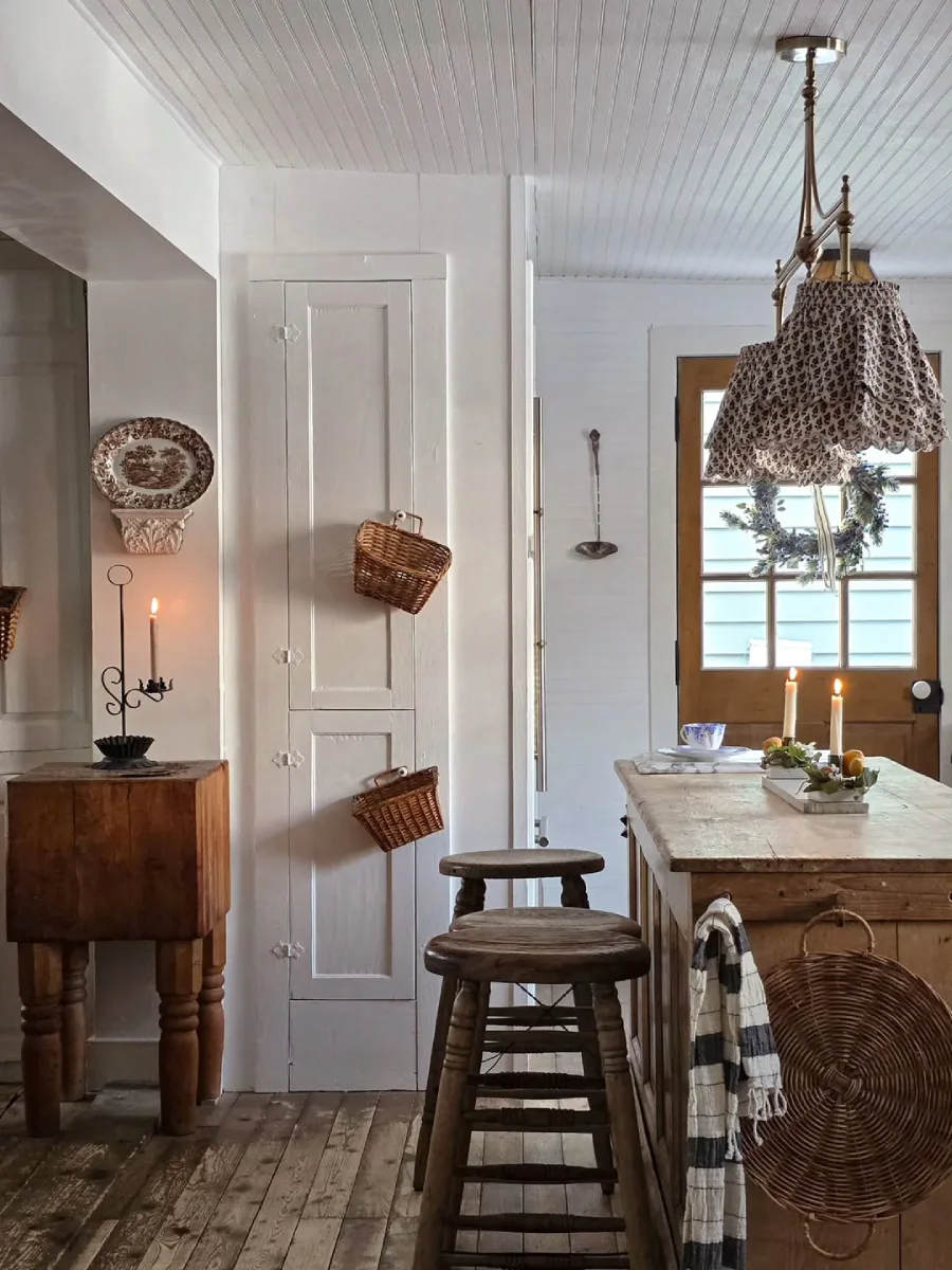 Detail area dapur rustic dengan balok pemotong daging kayu tebal island dapur berbahan kayu dengan bangku bulat dan lampu gantung kap kain