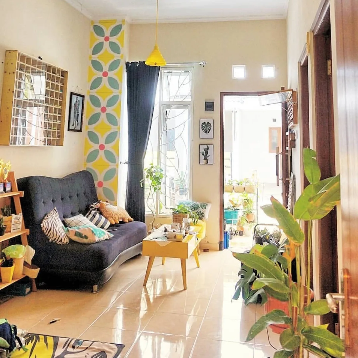 Interior ruang tamu bergaya retro modern dengan aksen warna kuning dan tanaman hias indoor.