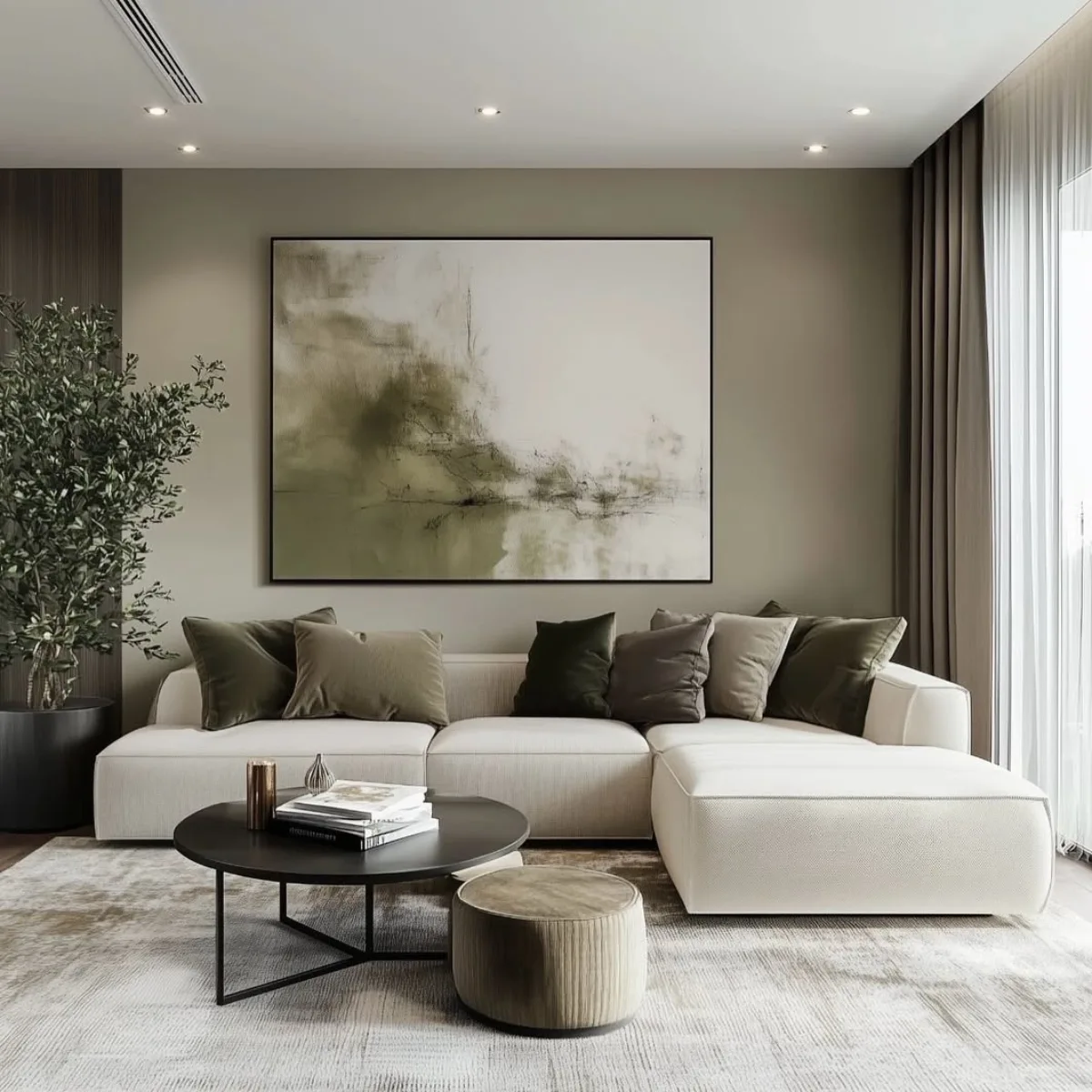 Ruang tamu elegan dengan dinding warna hijau zaitun muda, lukisan abstrak besar, tanaman indoor tinggi, dan sofa krem mewah.