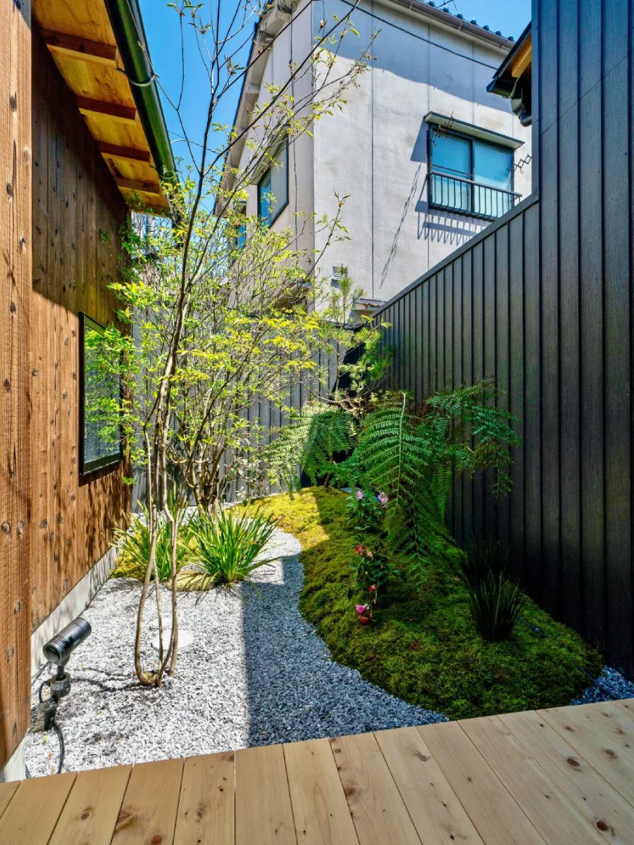 Taman Jepang bernuansa tradisional dengan kombinasi batu besar, kerikil, dan pohon kecil.