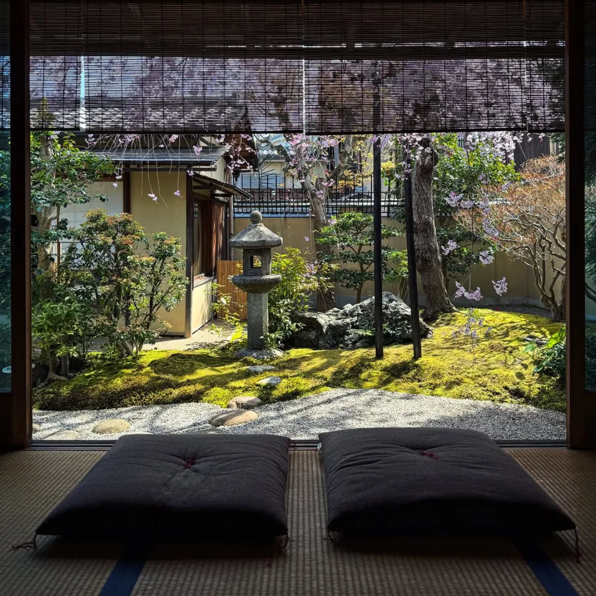 taman Jepang dengan elemen air, batu alam, dan tanaman hijau yang tertata tenang.