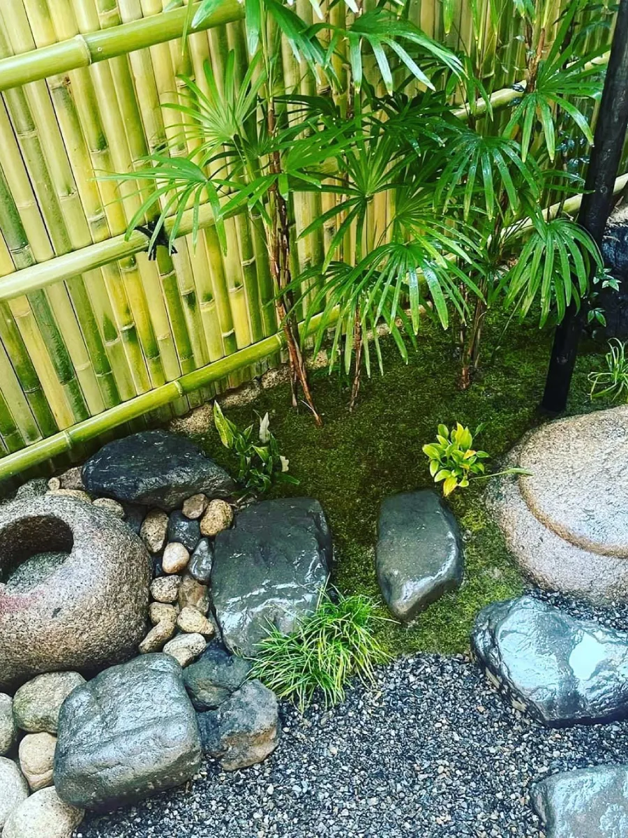 Area taman Jepang kecil dengan pancuran bambu dan elemen air tradisional.