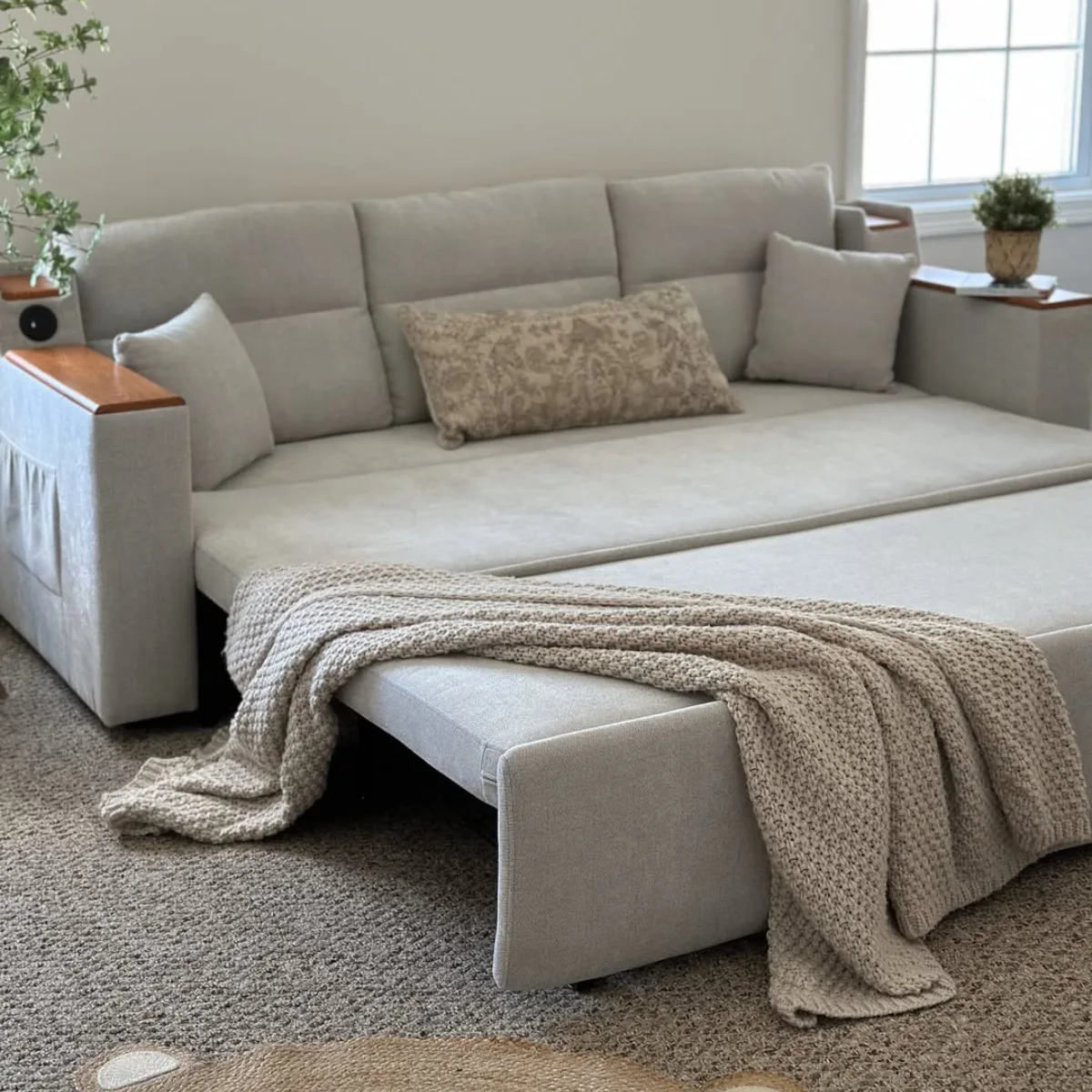 Sofa bed multifungsi warna abu-abu muda yang sedang dibuka menjadi tempat tidur, lengkap dengan fitur saku penyimpanan di bagian lengan. Cocok untuk bagian artikel yang membahas: Sofa Bed atau solusi ruang tamu kecil.