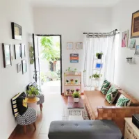 Ruang tamu minimalis modern dengan sofa kayu, tanaman hias, dan dekorasi estetik yang terlihat cantik, rapi, dan terang dengan pencahayaan alami