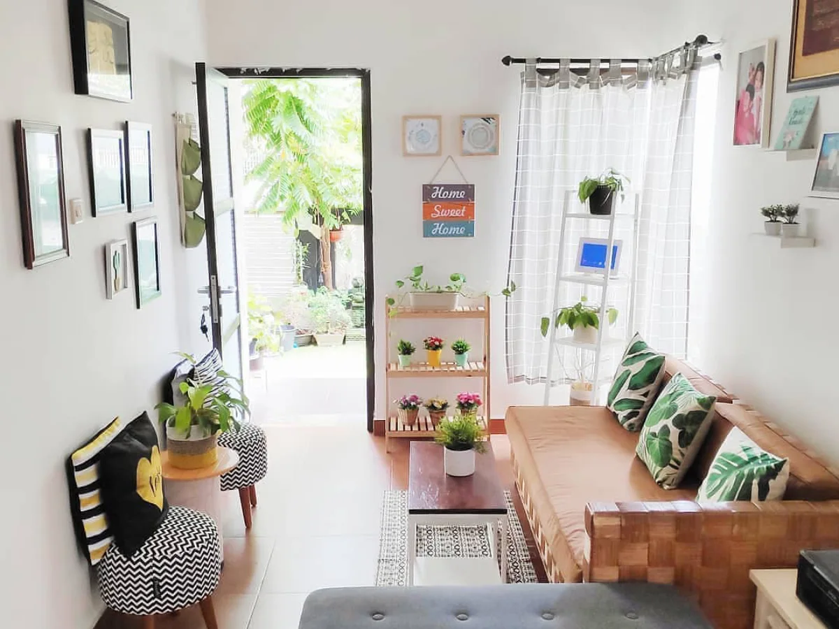Ruang tamu minimalis modern dengan sofa kayu, tanaman hias, dan dekorasi estetik yang terlihat cantik, rapi, dan terang dengan pencahayaan alami