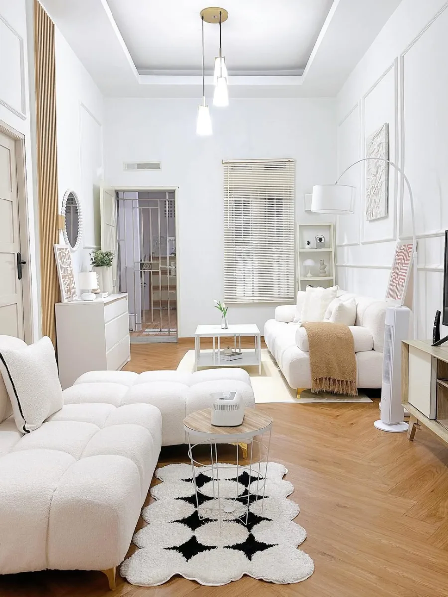 Inspirasi ruang tamu serba putih (all-white) modern dengan lantai vinyl motif herringbone dan karpet bertekstur.