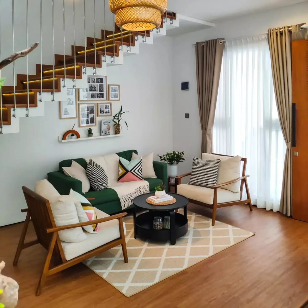 Ruang tamu minimalis modern di bawah tangga dengan lantai kayu dan lampu gantung anyaman.