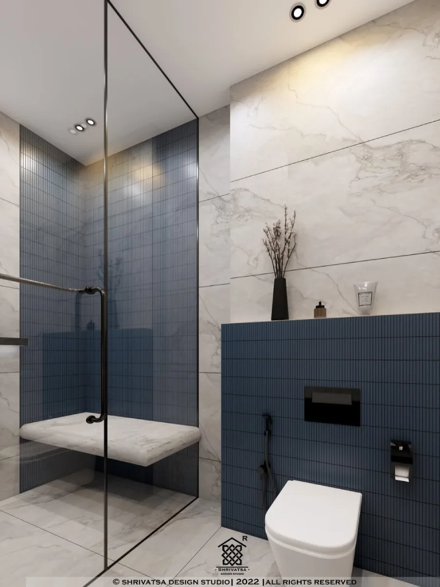 Sudut area shower dengan kombinasi dinding marmer putih dan ubin biru vertikal, dilengkapi bangku marmer melayang dan partisi kaca penuh.